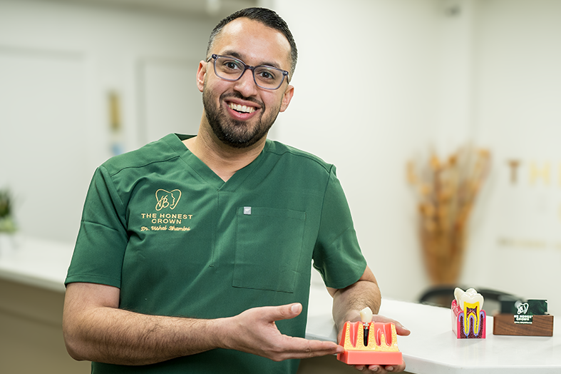 Dr. Bhambri holding a single dental implant model